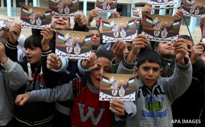 A Palestinian children holds posters of Palestinian President Mahmoud Abbas during a rally in the West Bank city of Nablus on Nov. 16, 2011 . Photo by Wagdi Eshtayah