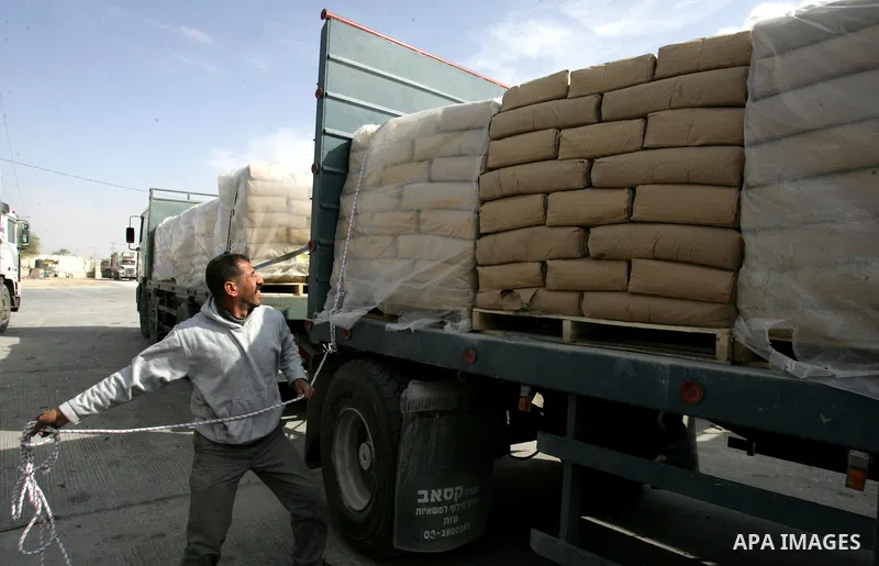 Palestinians check trucks loaded with construction materials at the Rafah crossing which entered through Israel's Kerem Shalom crossing in southern Gaza Strip on November 16, 2011. Israel allowed to enter the constructio...