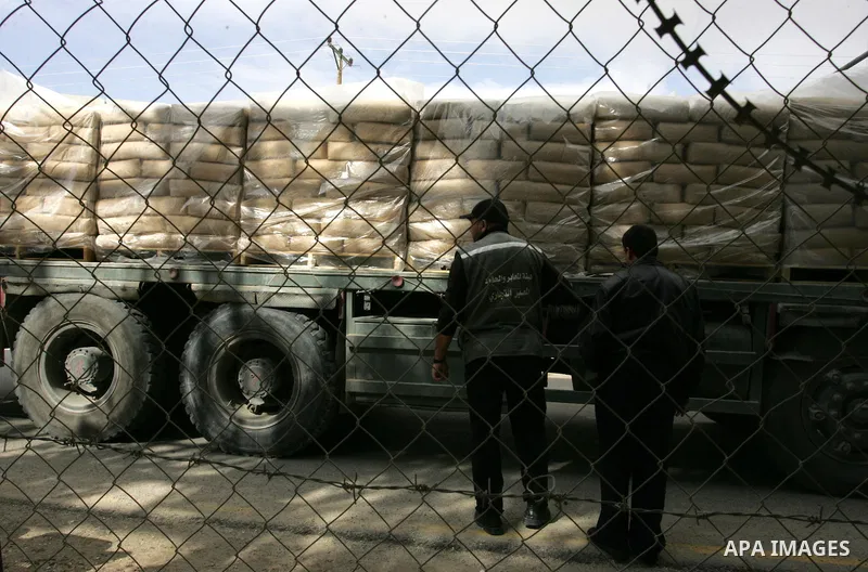 Palestinians check trucks loaded with construction materials at the Rafah crossing which entered through Israel's Kerem Shalom crossing in southern Gaza Strip on November 16, 2011. Israel allowed to enter the constructio...