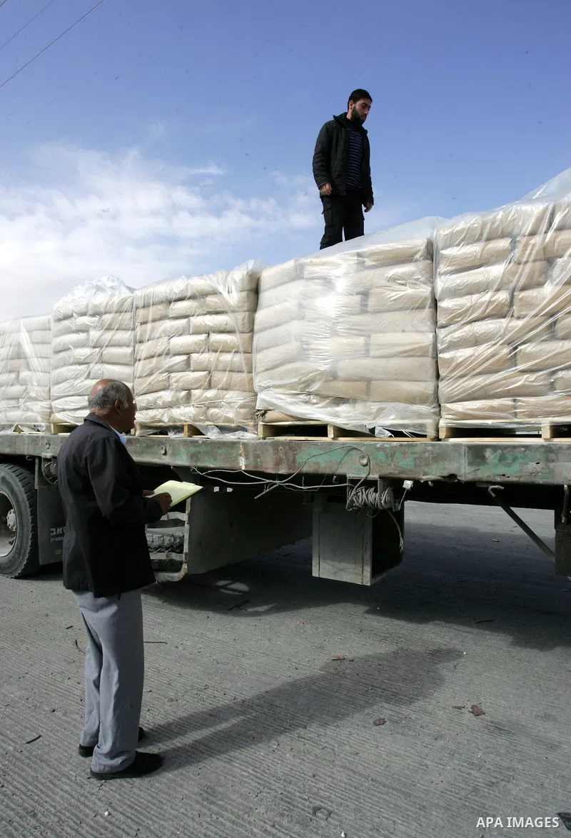Palestinians check trucks loaded with construction materials at the Rafah crossing which entered through Israel's Kerem Shalom crossing in southern Gaza Strip on November 16, 2011. Israel allowed to enter the constructio...