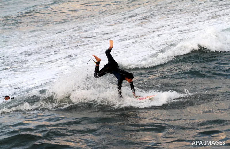 Palestinian youths surf in the Mediterranean Sea off the coast of Gaza City, as a cold and windy weather hits Gaza Strip, on Nov. 16,2011. Photo by Mohammed Asad