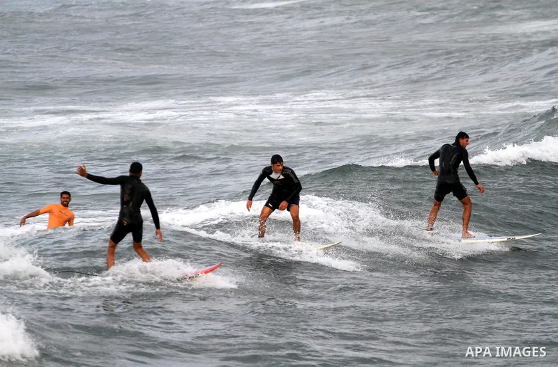 Palestinian youths surf in the Mediterranean Sea off the coast of Gaza City, as a cold and windy weather hits Gaza Strip, on Nov. 16,2011. Photo by Mohammed Asad