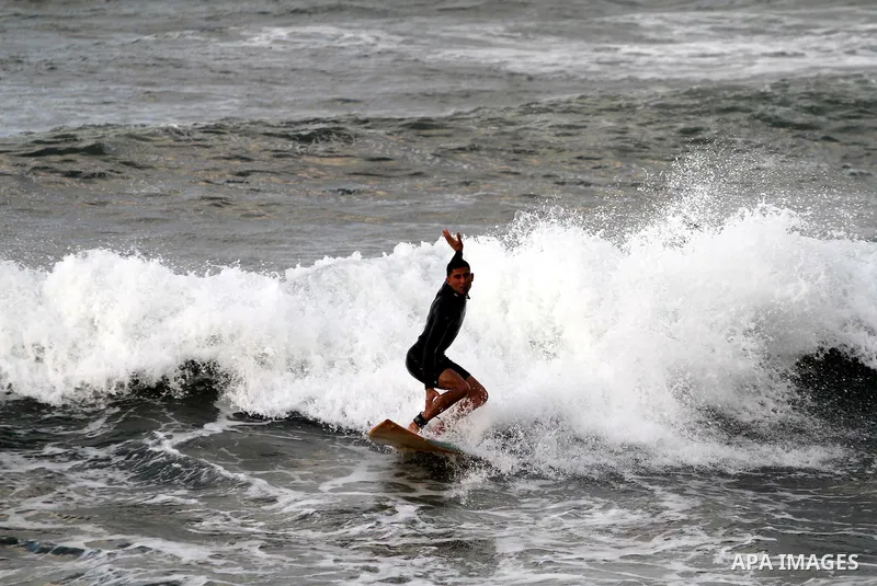 Palestinian youths surf in the Mediterranean Sea off the coast of Gaza City, as a cold and windy weather hits Gaza Strip, on Nov. 16,2011. Photo by Mohammed Asad