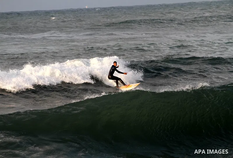 Palestinian youths surf in the Mediterranean Sea off the coast of Gaza City, as a cold and windy weather hits Gaza Strip, on Nov. 16,2011. Photo by Mohammed Asad