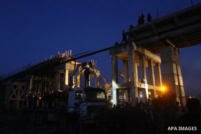 Palestinian rescue teams inspect the scene of a collapsed bridge on a main road in the central Gaza Strip that links Gaza City with the south, near Nusseirat, on November 17, 2011. Medical sources said two Palestinian wo...