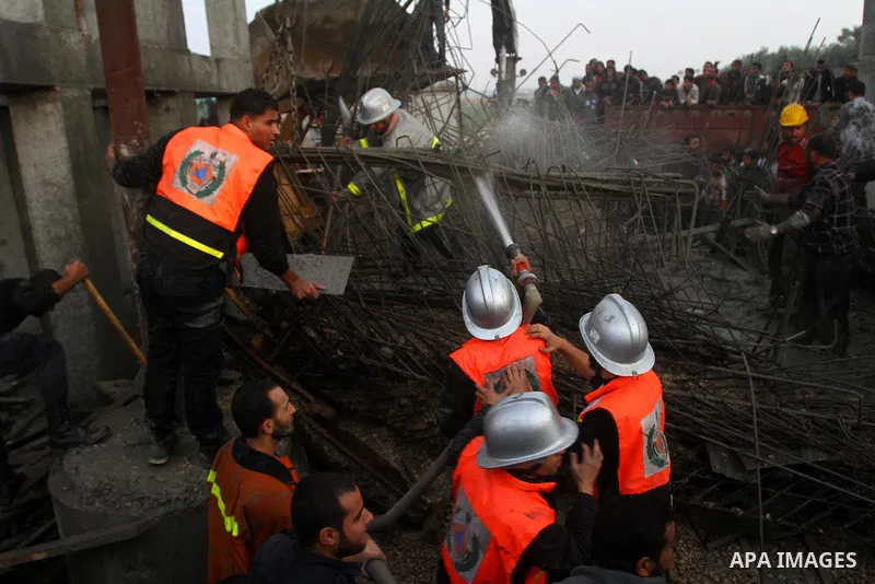 Palestinian rescue teams inspect the scene of a collapsed bridge on a main road in the central Gaza Strip that links Gaza City with the south, near Nusseirat, on November 17, 2011. Medical sources said two Palestinian wo...