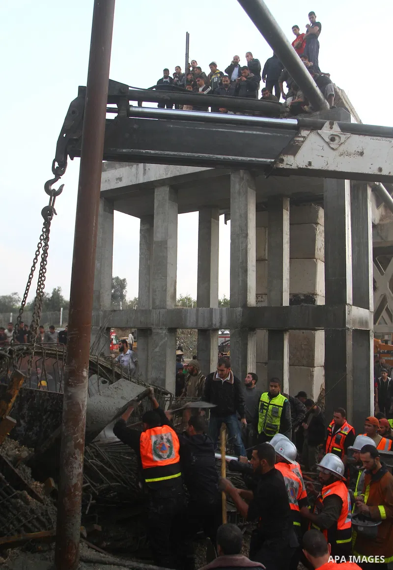 Palestinian rescue teams inspect the scene of a collapsed bridge on a main road in the central Gaza Strip that links Gaza City with the south, near Nusseirat, on November 17, 2011. Medical sources said two Palestinian wo...