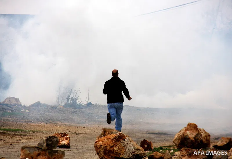 Palestinians run away from tear gas fired by Israeli security forces, who are seeking access to their land near Kufr Qaddum, near the northern West Bank Jewish settlement of Kdumim, Friday, Nov. 18, 2011. Photo by Wagdi...