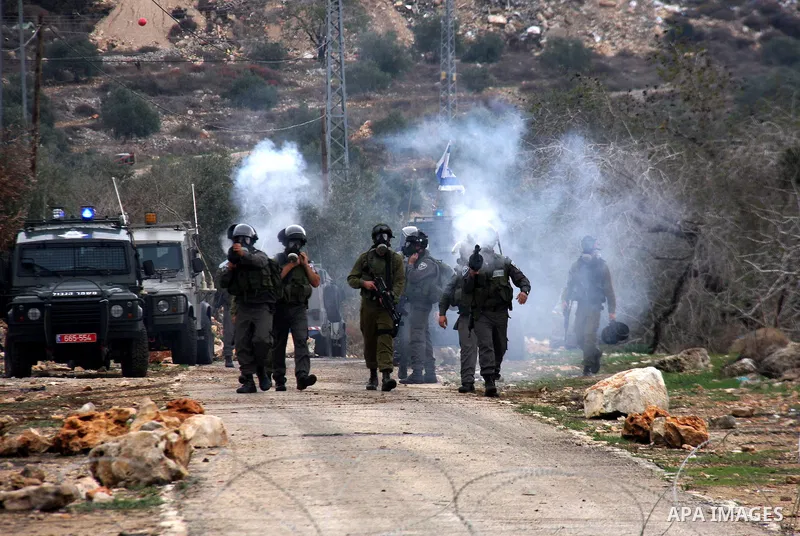 Israeli border police officers fire tear gas toward Palestinian demonstrators, who are seeking access to their land near Kufr Qaddum, near the northern West Bank Jewish settlement of Kdumim, Friday, Nov. 18, 2011. Photo...
