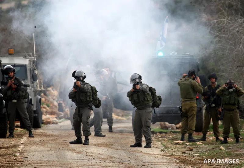 Israeli border police officers fire tear gas toward Palestinian demonstrators, who are seeking access to their land near Kufr Qaddum, near the northern West Bank Jewish settlement of Kdumim, Friday, Nov. 18, 2011. Photo...