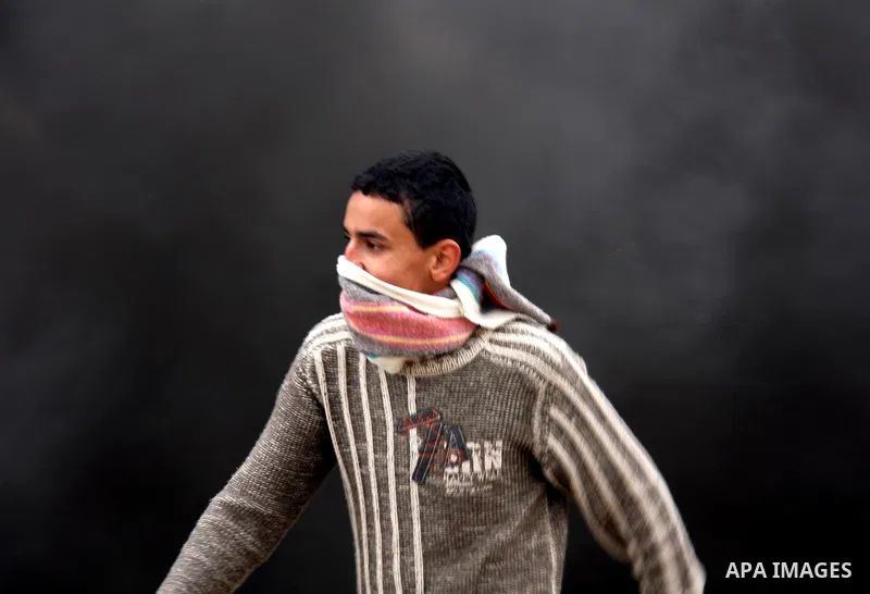 Palestinians run away from tear gas fired by Israeli security forces, who are seeking access to their land near Kufr Qaddum, near the northern West Bank Jewish settlement of Kdumim, Friday, Nov. 18, 2011. Photo by Wagdi...