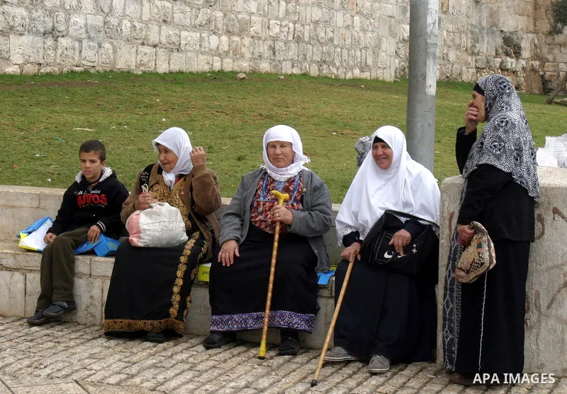Palestinian women sit outside Damascus Gate leading into the old city of Jerusalem from their way from Friday prayers in the Al-Aqsa Mosque compound, Islam's third holiest site, on November 18, 2011. Photo by Mahfouz Abu...