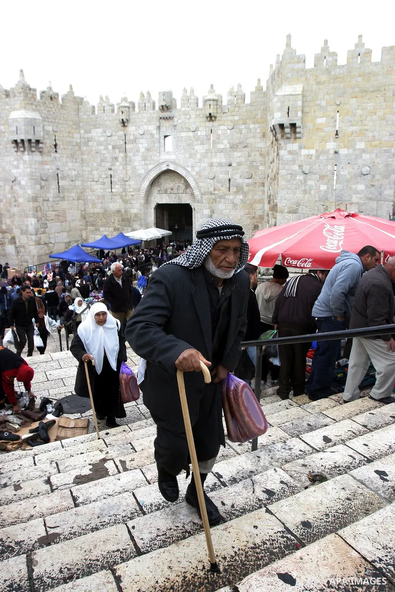 Palestinians walk outside Damascus Gate leading into the old city of Jerusalem from their way from Friday prayers in the Al-Aqsa Mosque compound, Islam's third holiest site, on November 18, 2011. Photo by Mahfouz Abu Tur...