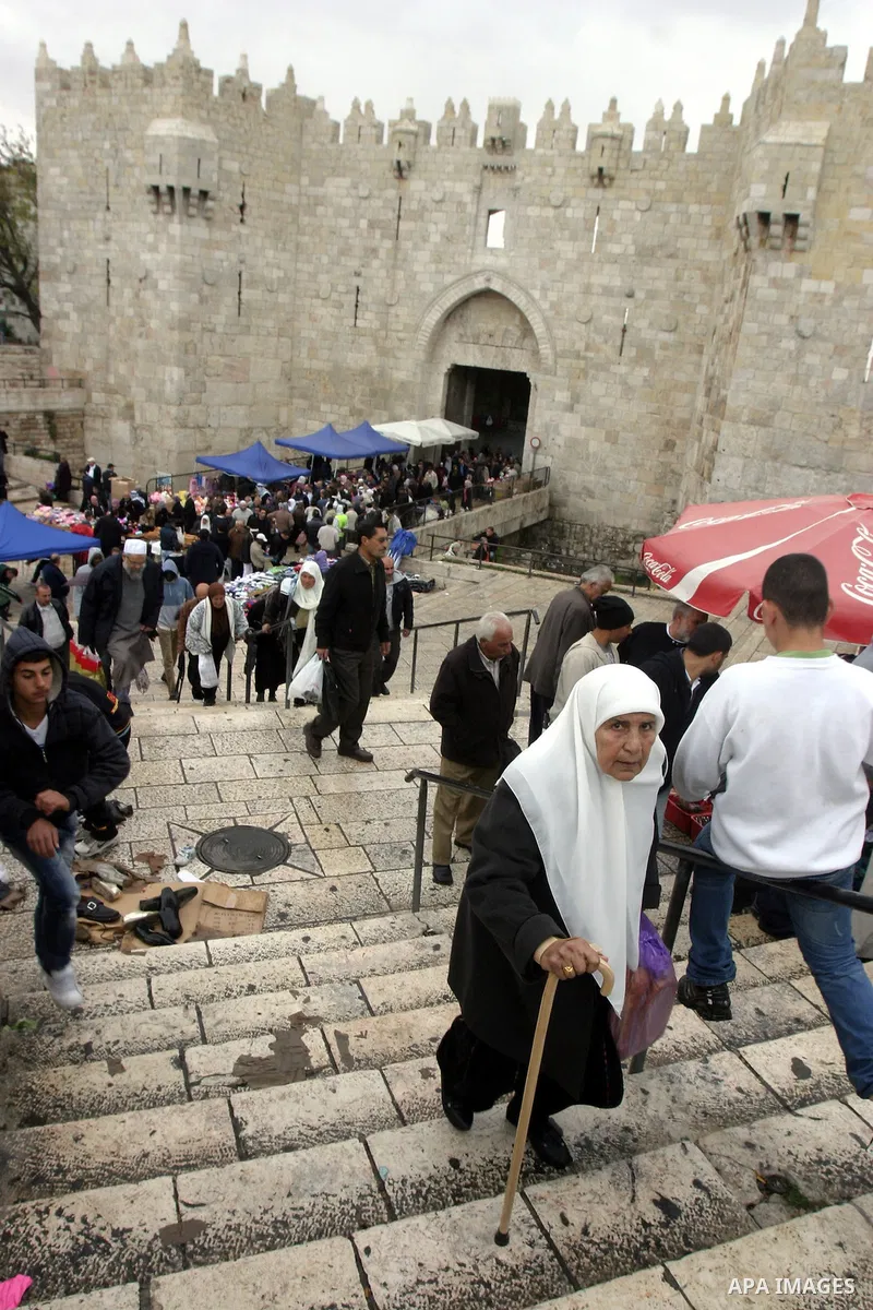 Palestinians walk outside Damascus Gate leading into the old city of Jerusalem from their way from Friday prayers in the Al-Aqsa Mosque compound, Islam's third holiest site, on November 18, 2011. Photo by Mahfouz Abu Tur...