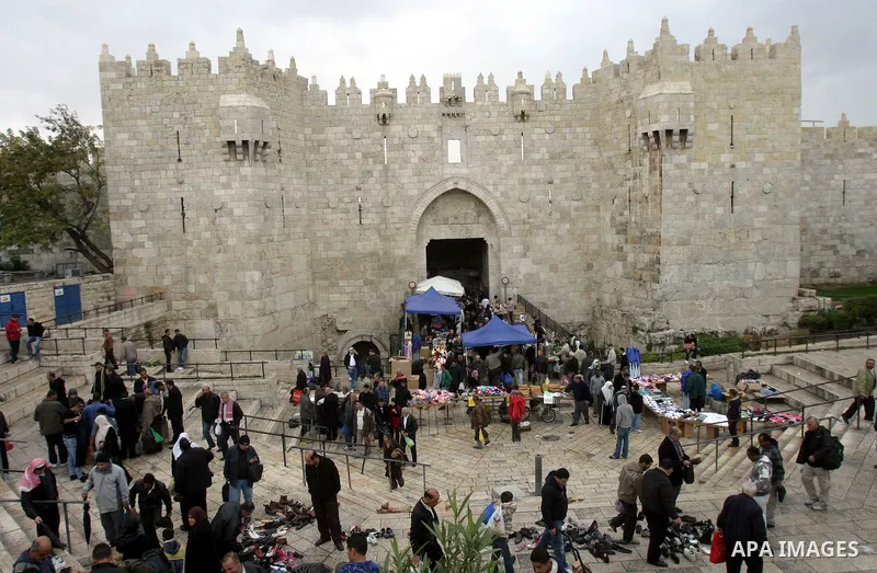 Palestinians walk outside Damascus Gate leading into the old city of Jerusalem from their way from Friday prayers in the Al-Aqsa Mosque compound, Islam's third holiest site, on November 18, 2011. Photo by Mahfouz Abu Tur...