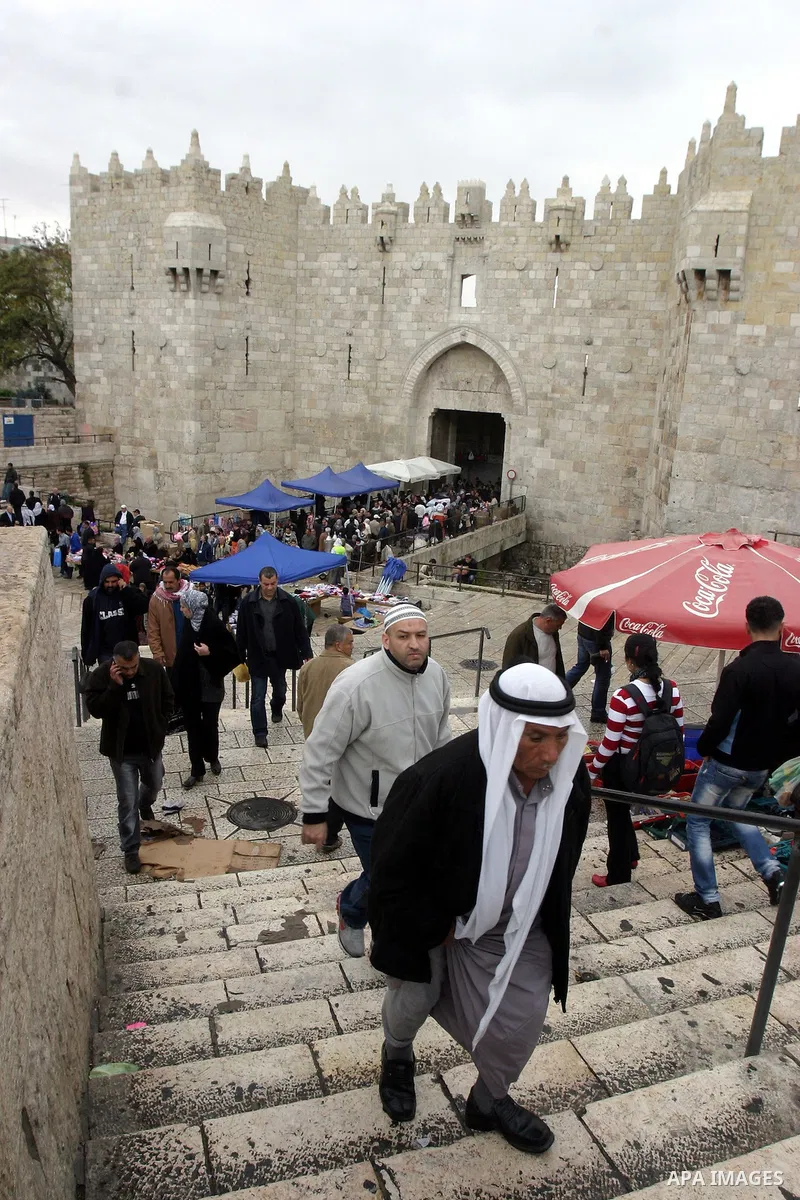 Palestinians walk outside Damascus Gate leading into the old city of Jerusalem from their way from Friday prayers in the Al-Aqsa Mosque compound, Islam's third holiest site, on November 18, 2011. Photo by Mahfouz Abu Tur...
