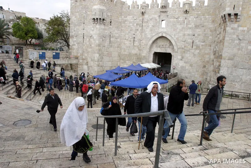 Palestinians walk outside Damascus Gate leading into the old city of Jerusalem from their way from Friday prayers in the Al-Aqsa Mosque compound, Islam's third holiest site, on November 18, 2011. Photo by Mahfouz Abu Tur...