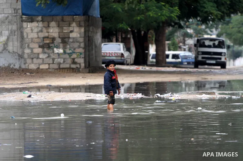 Palestinians walks through a flooded street after heavy rain and cold winds in Gaza City, On Nov. 19, 2011. Photo by Mohammed Asad