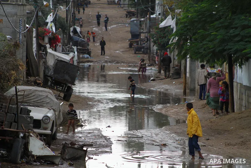 Palestinian boys play at a pool of rain water in refugee camp in Gaza Strip, On Nov. 19, 2011. Photo by Ashraf Amra
