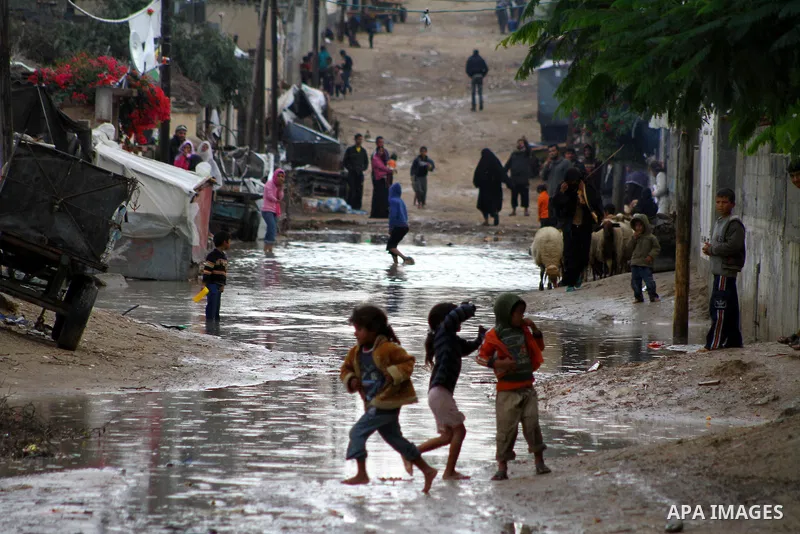 Palestinian boys play at a pool of rain water in refugee camp in Gaza Strip, On Nov. 19, 2011. Photo by Ashraf Amra