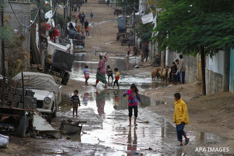 Palestinian boys play at a pool of rain water in refugee camp in Gaza Strip, On Nov. 19, 2011. Photo by Ashraf Amra