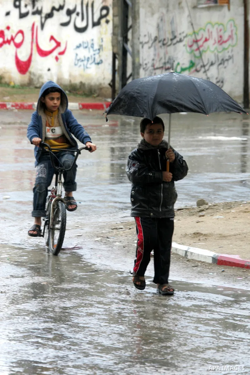 Palestinians walk a falling heavy rain and cold winds in the Rafah refugee camp, southern Gaza Strip on Nov. 19, 2011. Photo by Abed Rahim Khatib