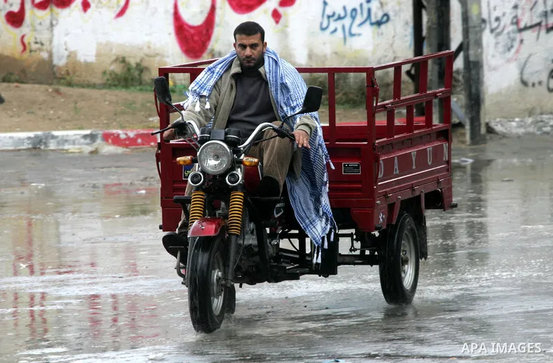 Palestinians walk a falling heavy rain and cold winds in the Rafah refugee camp, southern Gaza Strip on Nov. 19, 2011. Photo by Abed Rahim Khatib