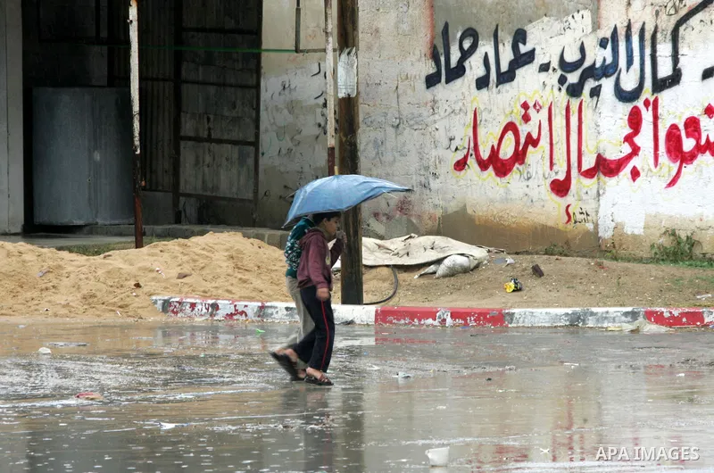 Palestinians walk a falling heavy rain and cold winds in the Rafah refugee camp, southern Gaza Strip on Nov. 19, 2011. Photo by Abed Rahim Khatib