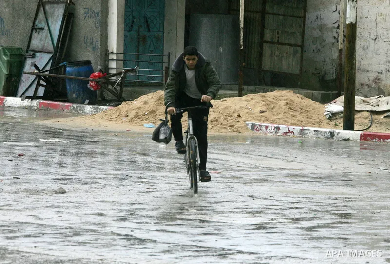 Palestinians walk a falling heavy rain and cold winds in the Rafah refugee camp, southern Gaza Strip on Nov. 19, 2011. Photo by Abed Rahim Khatib