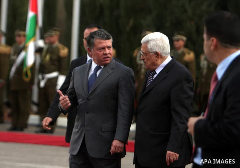 Palestinian President Mahmoud Abbas and King Abdullah of Jordan walk together during a welcoming ceremony in the West Bank city of Ramallah November 21, 2011. Abdullah arrived in Ramallah on Monday for a rare visit to th...