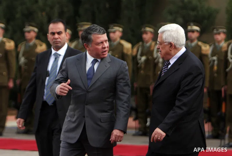 Palestinian President Mahmoud Abbas and King Abdullah of Jordan walk together during a welcoming ceremony in the West Bank city of Ramallah November 21, 2011. Abdullah arrived in Ramallah on Monday for a rare visit to th...