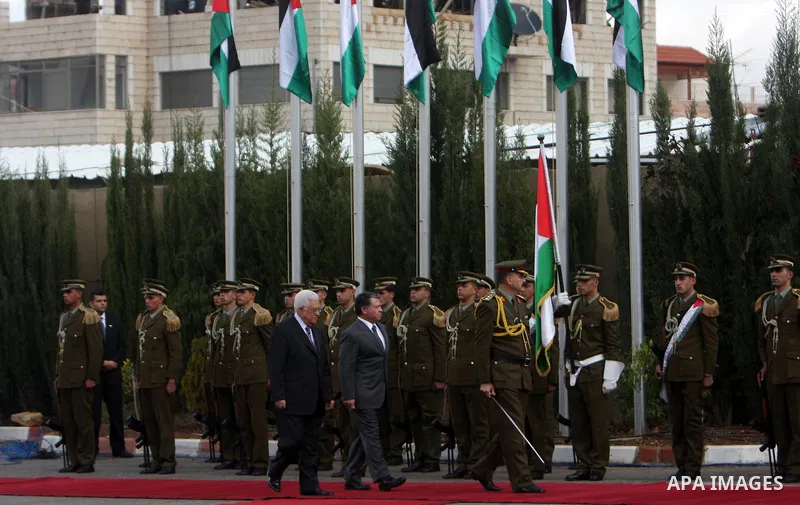 Palestinian President Mahmoud Abbas and King Abdullah of Jordan walk together during a welcoming ceremony in the West Bank city of Ramallah November 21, 2011. Abdullah arrived in Ramallah on Monday for a rare visit to th...