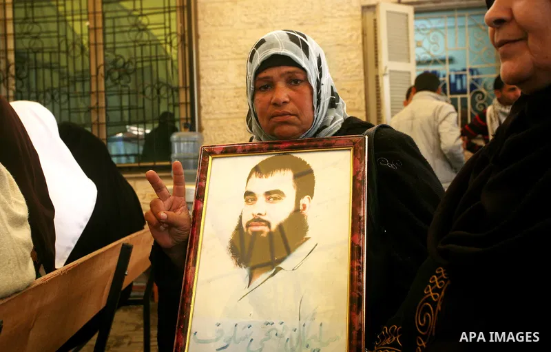 Palestinians hold pictures of their prisoned relatives in Israeli jails as they gather in a weekly activity calling for their liberty at the Red Cross headquarters in Gaza City on Nov. 21, 2011. About 7000 prisoners are...