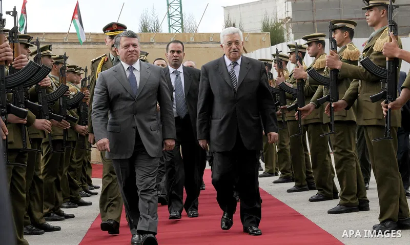 Palestinian President Mahmoud Abbas and King Abdullah of Jordan walk together during a welcoming ceremony in the West Bank city of Ramallah November 21, 2011. Abdullah arrived in Ramallah on Monday for a rare visit to th...