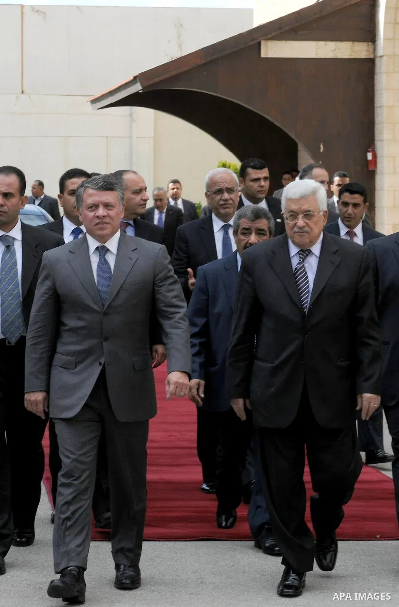 Palestinian President Mahmoud Abbas and King Abdullah of Jordan walk together during a welcoming ceremony in the West Bank city of Ramallah November 21, 2011. Abdullah arrived in Ramallah on Monday for a rare visit to th...