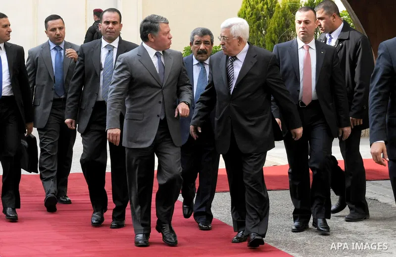 Palestinian President Mahmoud Abbas and King Abdullah of Jordan walk together during a welcoming ceremony in the West Bank city of Ramallah November 21, 2011. Abdullah arrived in Ramallah on Monday for a rare visit to th...