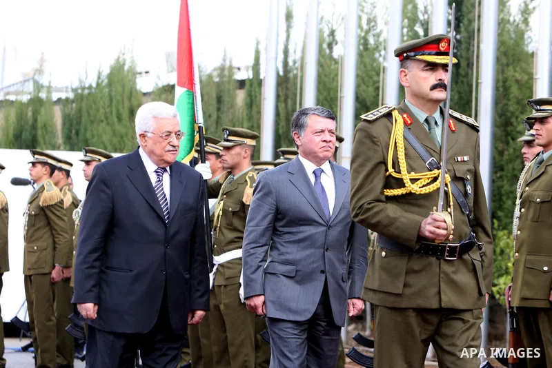 Palestinian President Mahmoud Abbas and King Abdullah of Jordan walk together during a welcoming ceremony in the West Bank city of Ramallah November 21, 2011. Abdullah arrived in Ramallah on Monday for a rare visit to th...