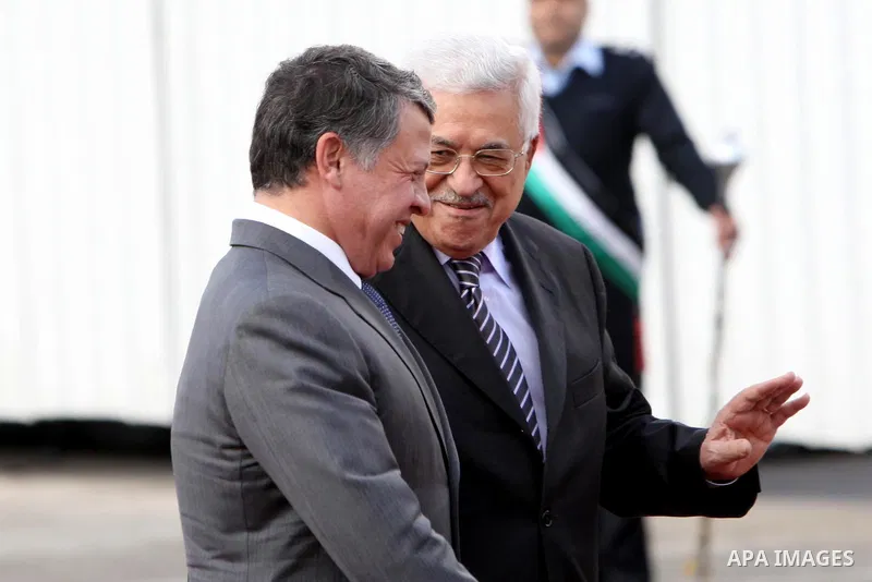 Palestinian President Mahmoud Abbas and King Abdullah of Jordan walk together during a welcoming ceremony in the West Bank city of Ramallah November 21, 2011. Abdullah arrived in Ramallah on Monday for a rare visit to th...