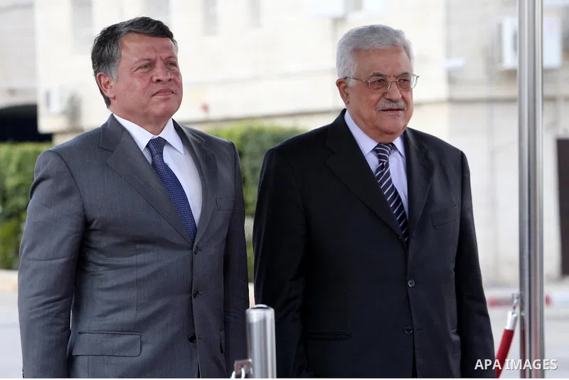 Palestinian President Mahmoud Abbas and King Abdullah of Jordan walk together during a welcoming ceremony in the West Bank city of Ramallah November 21, 2011. Abdullah arrived in Ramallah on Monday for a rare visit to th...