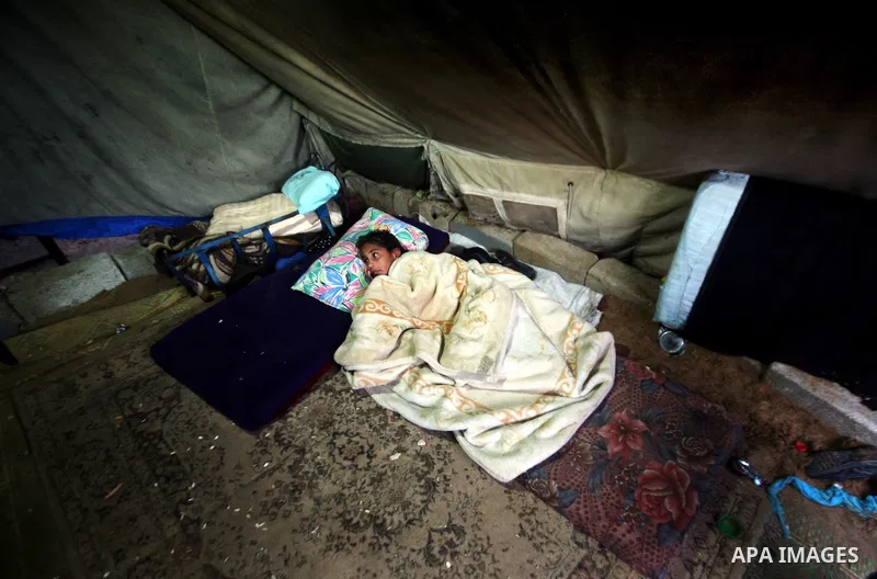 Palestinian bedouins sit inside their tent during heavy rain and cold winds in a camp for poor people in Al-Nussirat refugee camp, central Gaza Strip on 21 November 2011. Photo by Ali Jadallah