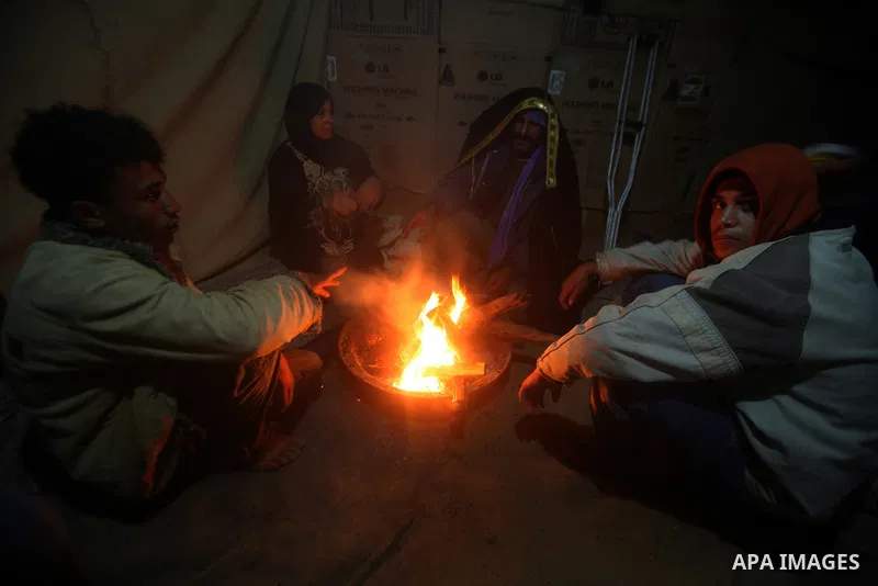 Palestinian bedouins sit inside their tent during heavy rain and cold winds in a camp for poor people in Al-Nussirat refugee camp, central Gaza Strip on 21 November 2011. Photo by Ali Jadallah