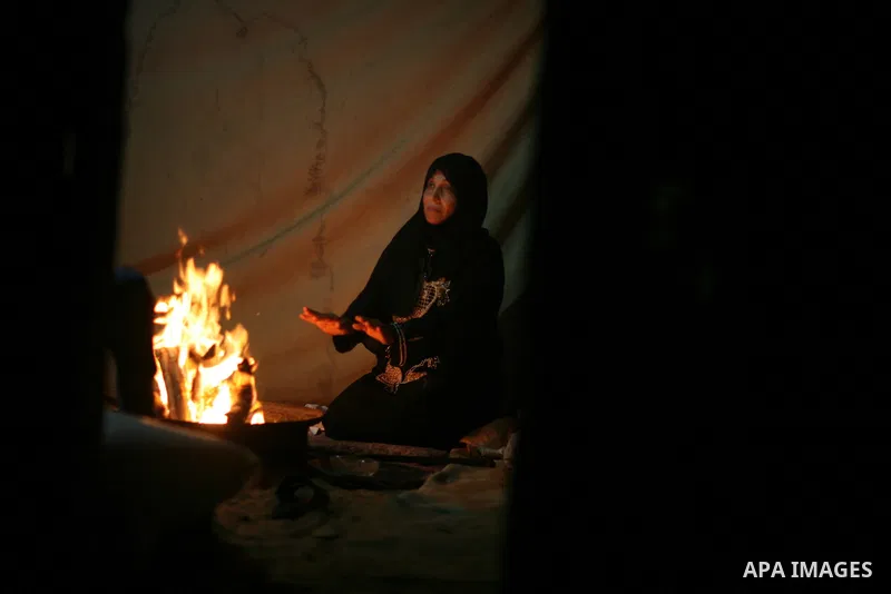 Palestinian bedouins sit inside their tent during heavy rain and cold winds in a camp for poor people in Al-Nussirat refugee camp, central Gaza Strip on 21 November 2011. Photo by Ali Jadallah