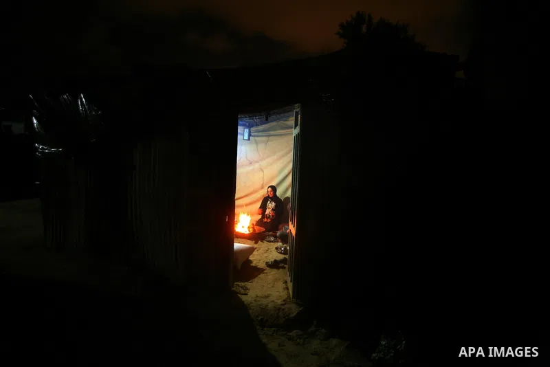 Palestinian bedouins sit inside their tent during heavy rain and cold winds in a camp for poor people in Al-Nussirat refugee camp, central Gaza Strip on 21 November 2011. Photo by Ali Jadallah