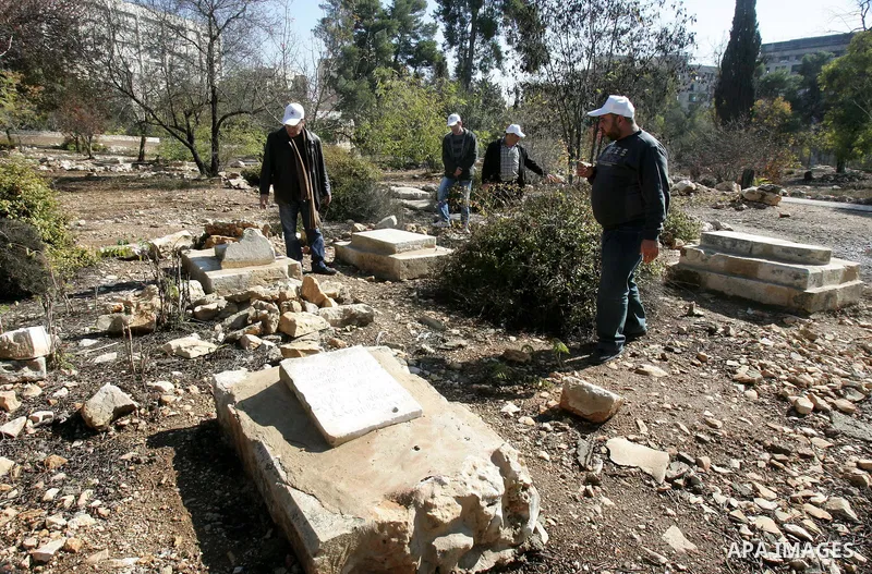 Palestinians inspect desecrated headstone at a Muslim graveyard in Jerusalem November 22, 2011. Israeli police launched an investigation into the desecration of headstones discovered, but believed to have happened severa...