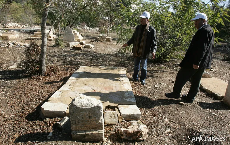 Palestinians inspect desecrated headstone at a Muslim graveyard in Jerusalem November 22, 2011. Israeli police launched an investigation into the desecration of headstones discovered, but believed to have happened severa...