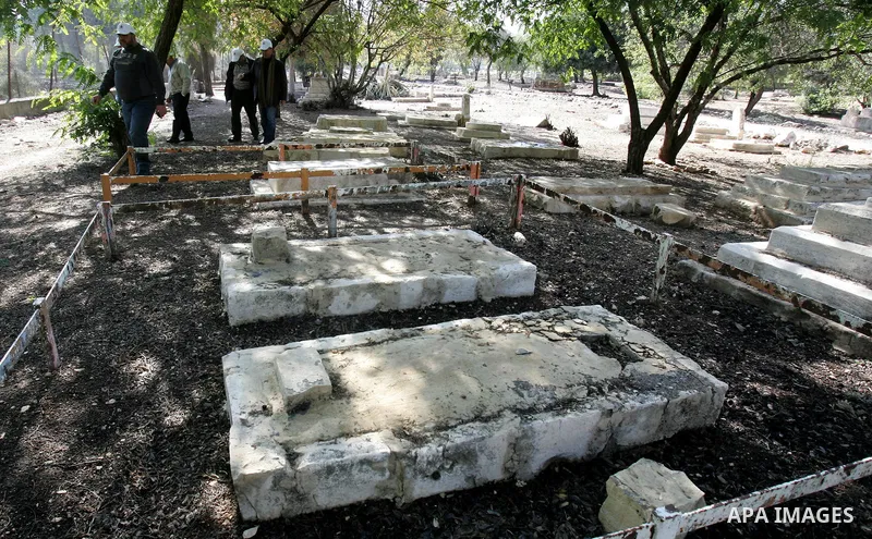 Palestinians inspect desecrated headstone at a Muslim graveyard in Jerusalem November 22, 2011. Israeli police launched an investigation into the desecration of headstones discovered, but believed to have happened severa...