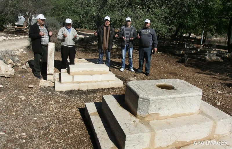 Palestinians inspect desecrated headstone at a Muslim graveyard in Jerusalem November 22, 2011. Israeli police launched an investigation into the desecration of headstones discovered, but believed to have happened severa...