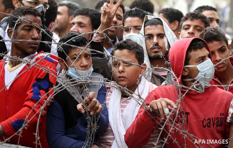 Egyptian protesters gather near barbed wire and concrete barricades around the Interior Ministry, near Cairo's Tahrir Square, November 24, 2011. A truce between Egyptian riot police and protesters succeeded on Thursday i...
