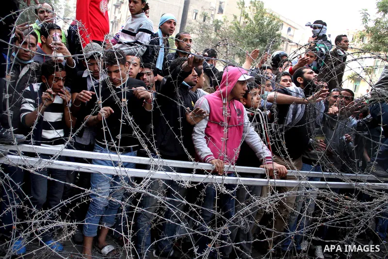 Egyptian protesters gather near barbed wire and concrete barricades around the Interior Ministry, near Cairo's Tahrir Square, November 24, 2011. A truce between Egyptian riot police and protesters succeeded on Thursday i...