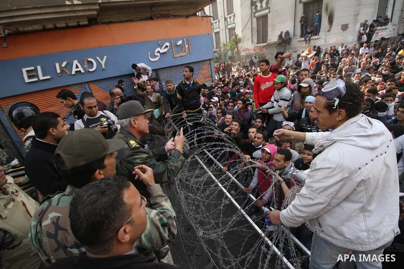 Egyptian protesters gather near barbed wire and concrete barricades around the Interior Ministry, near Cairo's Tahrir Square, November 24, 2011. A truce between Egyptian riot police and protesters succeeded on Thursday i...